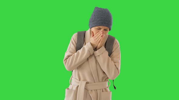 Woman in a Coat Walking and Coughing on a Green Screen, Chroma Key.