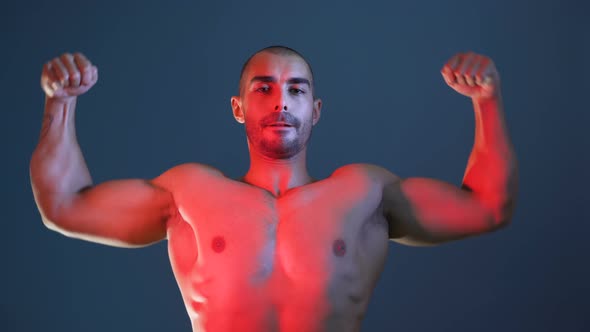 Male Fitness Model Showing Muscular Arms, Chest and Shoulders, Posing for Photo Session