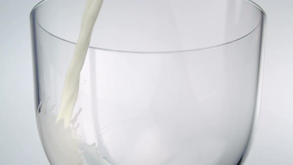 Slo-motion milk being poured into glass
