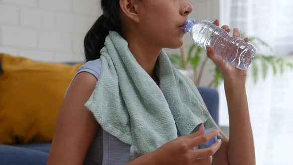 Young Asian woman exercising at home in a living room.