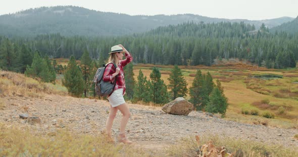 Woman Is Walking By with Fall Nature View. Smiling Attractive Traveler Backpack