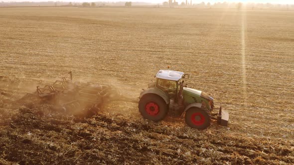 Top View of Green Modern Tractor Plowing Field