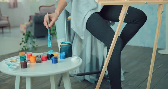 Beautiful Girl Paints a Picture at the Easel