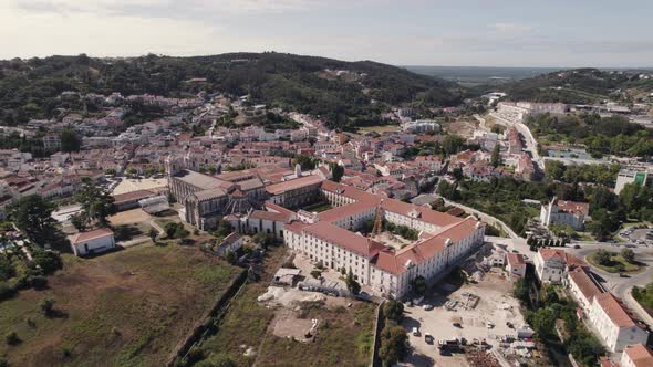 Portugal historical cityscape and catholic monastic complex Alcobaça monastery, aerial pan shot.