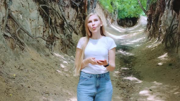 Positive Blonde Woman Making Faces in Natural Loess Ravine