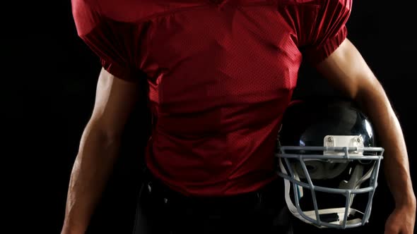 American football player holding a ball and head gear 4k