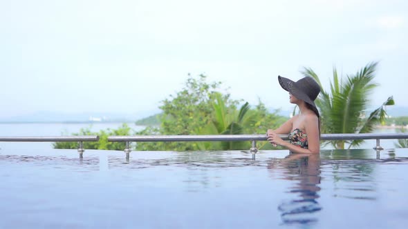 Young asian woman enjoy around outdoor swimming pool for leisure