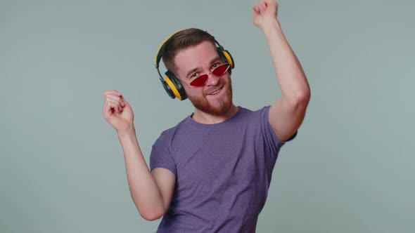 Cheerful Attractive Man Listening Music Via Headphones and Dancing Disco Fooling Around Having Fun