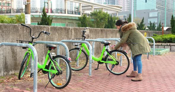 Woman using share bike in city