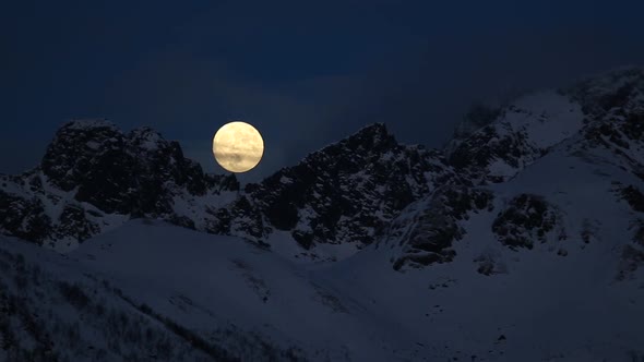 Watching a very amazing full moon set, Norway.The moon moves between the cold mountains.