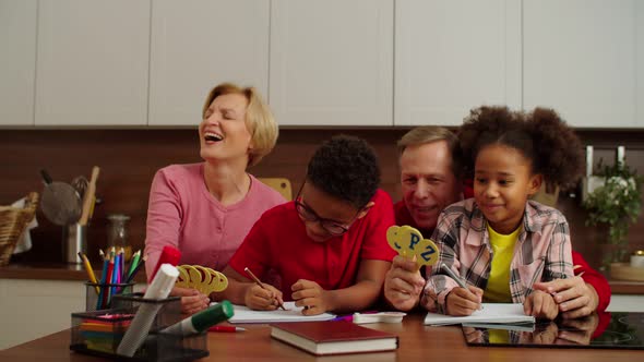 Caring Grandparents Teaching Alphabet to Adorable Multiracial Kids Indoors