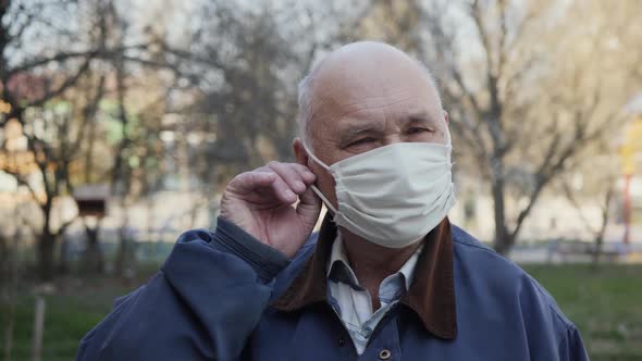 Elderly Man Taking Off His Face Mask