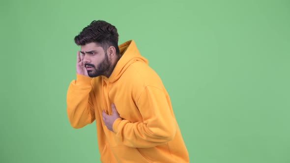 Stressed Young Overweight Bearded Indian Man Listening and Getting Bad News