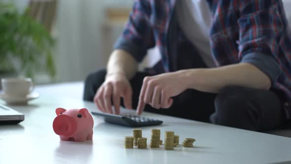 Man Calculating Money, Putting Coins Into Piggy Bank, Family Budget Planning