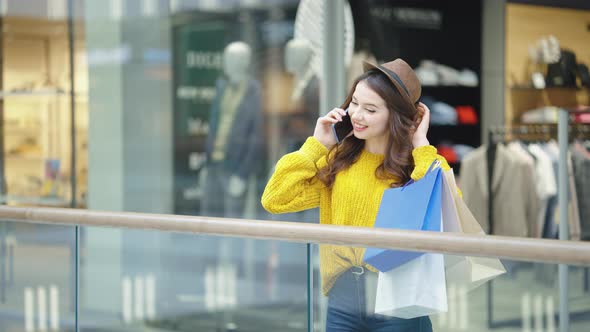 Woman with Purchases Talking on Phone