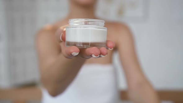 Female Hands Opening Jar with Cream on the White Background