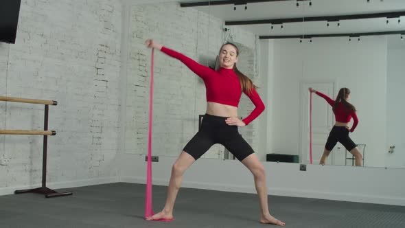 Active Fit Female Doing Banded Sumo Squat at Gym