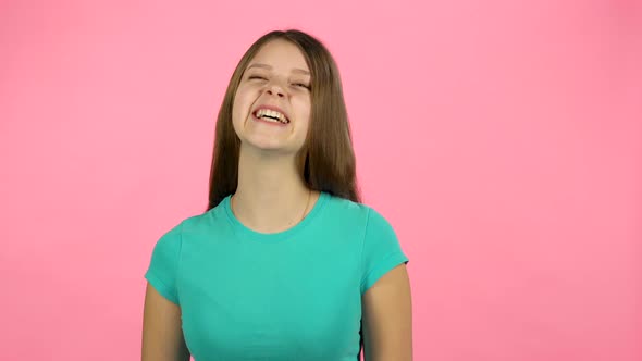 Young Female Is Laughing in the Studio on Pink Background