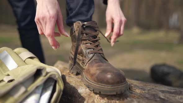 Closeup Female Hands Tying Shoelaces on Boot on Sunny Summer Spring Autumn Day in Forest