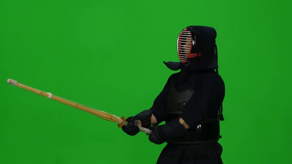 Masculine Kendo Warrior Practicing Martial Art with the Bamboo Bokken on Green Screen. CLose Up