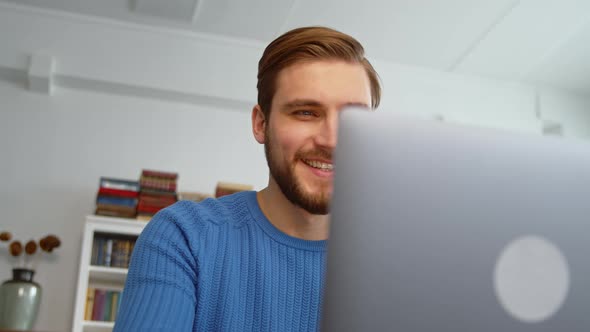 Smiling teacher typing on laptop keyboard at work desk