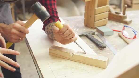 Man in Apron Works with Chisel in a Carpentry Shop