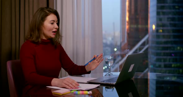 Businesswoman Sitting in an Office in the Business Center of the Table, Standing in Front of Her