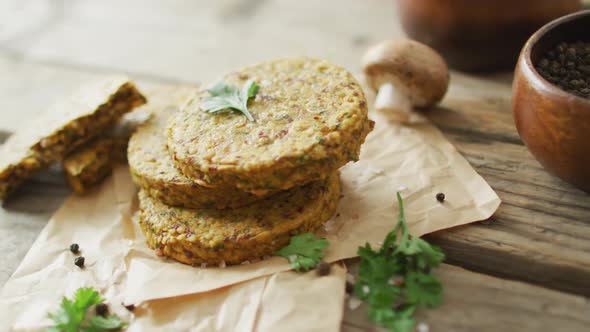 Video of fresh leaves and vegetarian burgers over wooden background