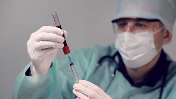 Doctor in the Laboratory, Draws Blood From a Test Tube Into a Syringe for Blood Analysis. Blood Test