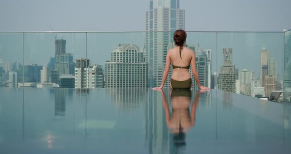 Woman Sit at The Infinity Swimming Pool