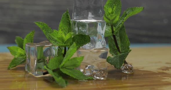 Ice Cubes and Mint Leaves Isolated on Wooden Cutting Board