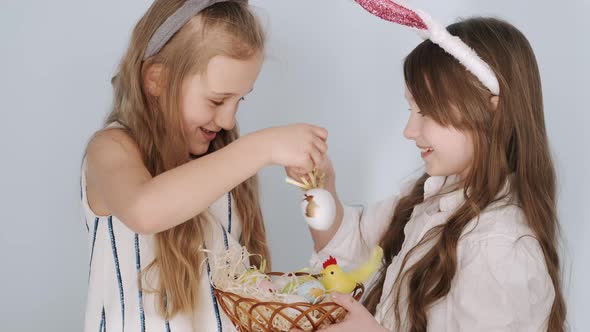 Two Girls Friends in Bunny Ears Holding Easter Eggs on Holiday