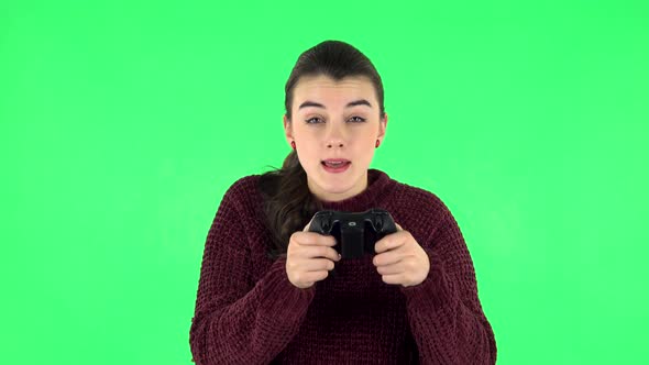 Girl Playing a Video Game Using a Wireless Controller and Loses. Green Screen