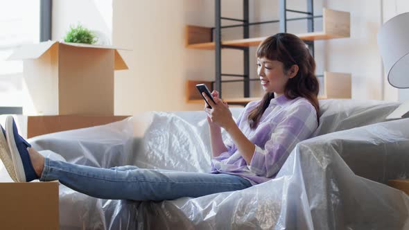 Asian Woman with Smartphone Moving Into New Home