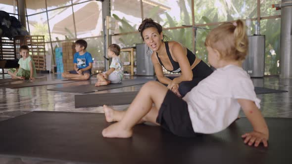 Toddler And Other Children Sitting On A Mat During Yoga Class In Koh Phangan Spiritual Center