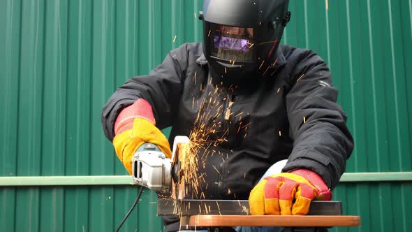 Man Cuts Metal with Angle Grinder Machine