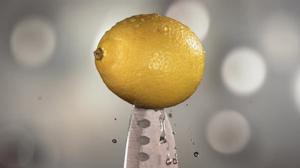 Fresh Lemon Falling Down with Water on Knife Stuck