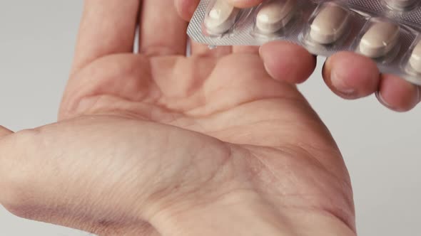 Shaking Hand of a Man Who is Taking a Pill Capsule From the Box at Home