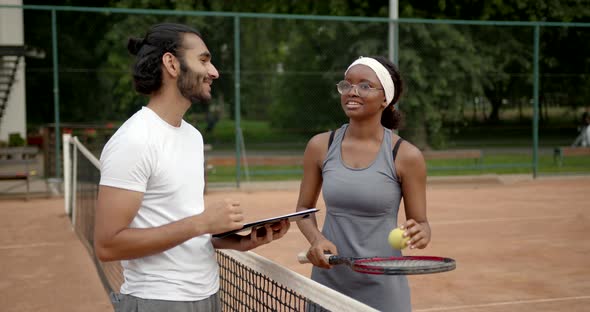 Black Woman Tennis Player and Coach on Tennis Court