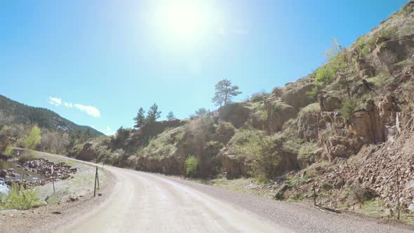 POV point of view -Driving on mountain dirt road in the Spring.