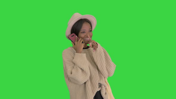 Smiling African American Woman in Knitwear and Hat Talking on Her Phone on a Green Screen, Chroma