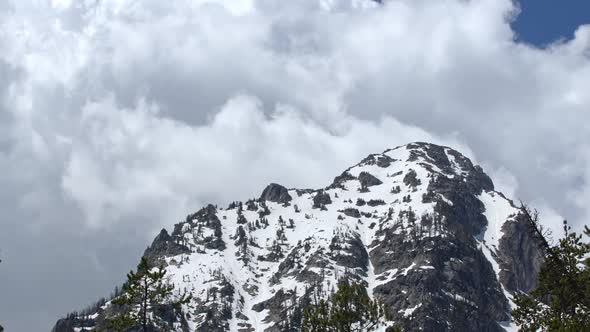 Clouds slowly moving over snow capped mountain peak in the Grand Tetons