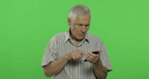 Senior Man Works on a Smartphone. Handsome Old Man on Chroma Key Background