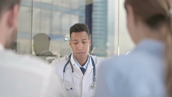 Rear Back View of Upset Couple Having Conversation with Doctor