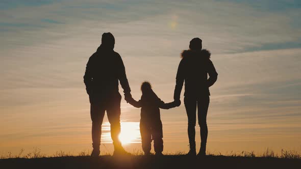 Silhouette Happy Child with Mother and Father Family at Sunset