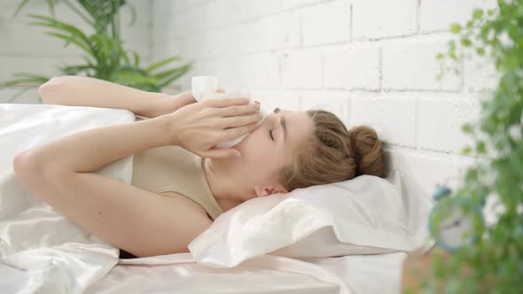 Beautiful Young Woman Has Runny Nose in Bed