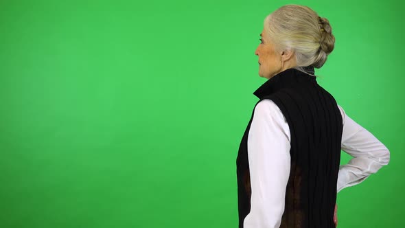 An elderly woman looks around,  - green screen studio