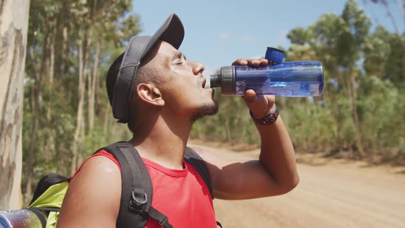 Sporty mixed race man with prosthetic leg drinking water