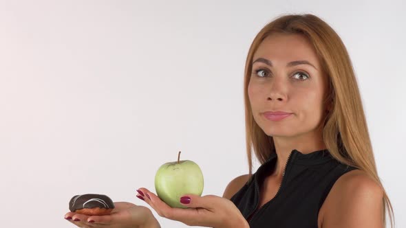 Young Woman Looking Confused Choosing Between Healthy and Junk Food