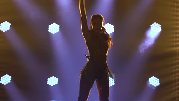 A Passionate Female Dancer in a Short Iridescent Dress Is Dancing Salsa in the Spotlight. Close Up